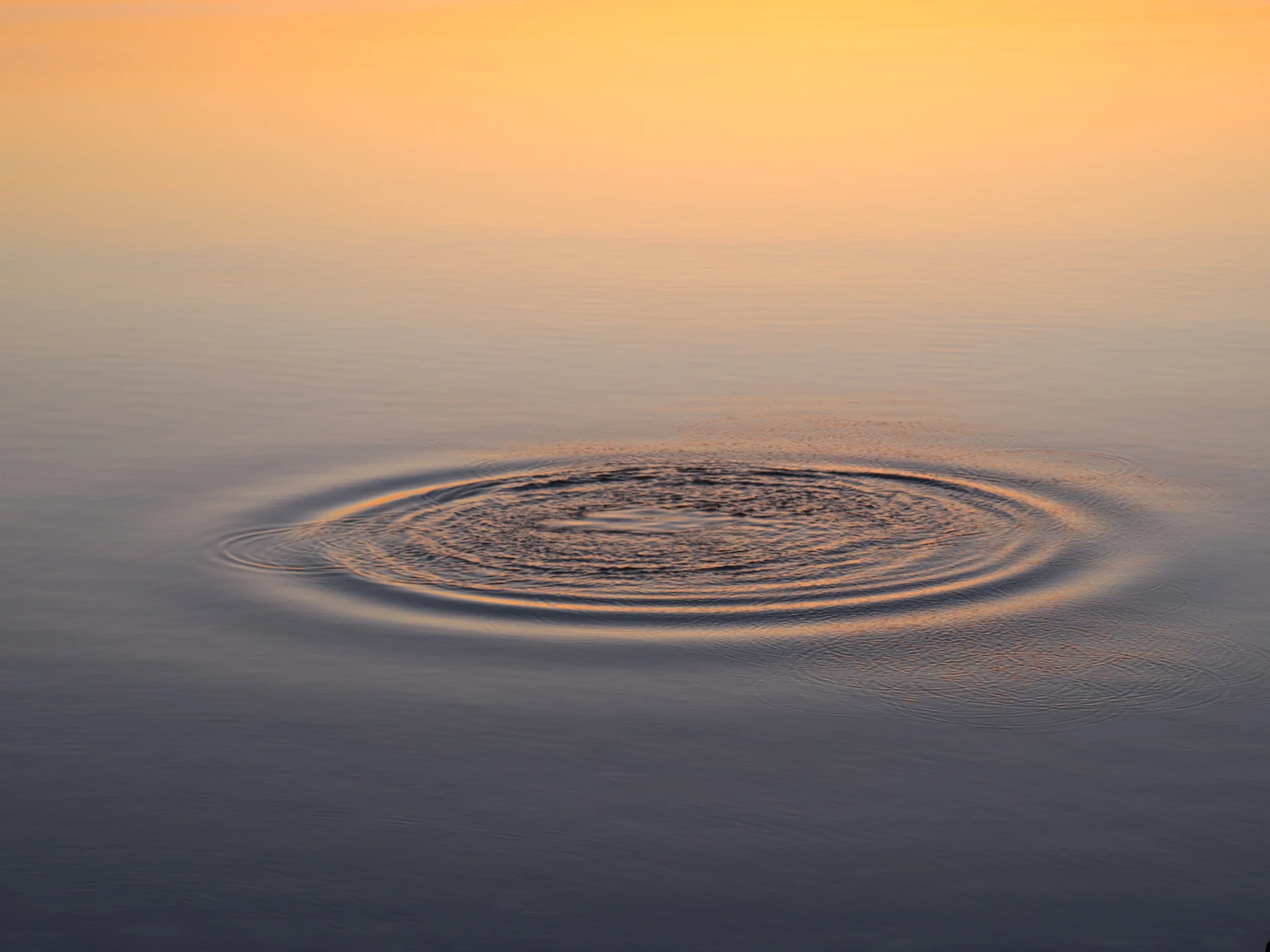 Delikatne kręgi na wodzie, symbolizujące rozchodzący się wpływ drobnych zmian.