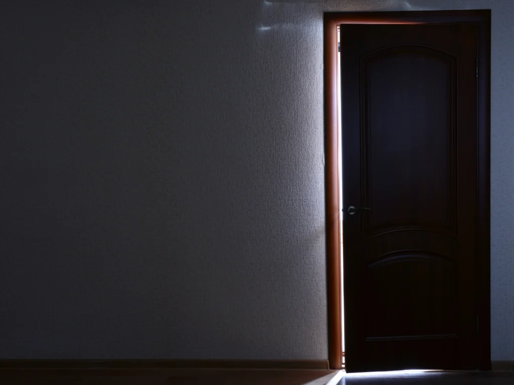 uchylone drzwi symbolizujące wyjście z mentalności ofiary i moment podjęcia odpowiedzialności